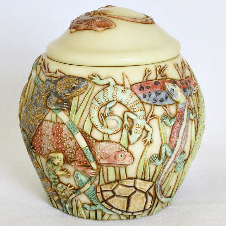 harmony ball the masquerade jardinia decorative lidded jar, image showing extended view of gila monster, orange lizard. green geckos, green turtle