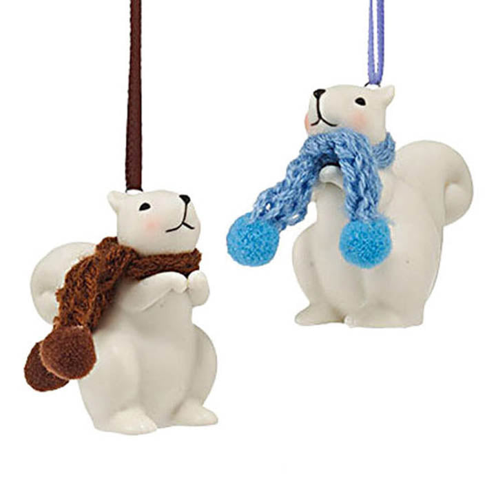 department 56 white porcelain squirrel ornaments, one wearing a brown knit scarf the other a blue knit scarf hanging from color coordinating ribbons
