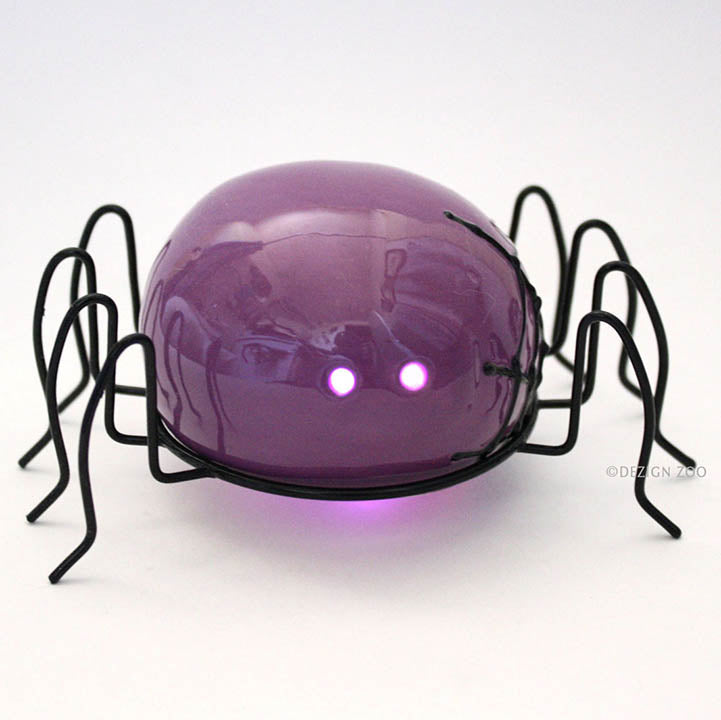 small purple spider halloween figurine with black metal legs front view showing purple LED eyes