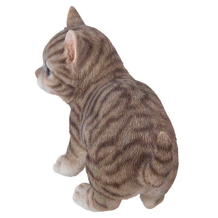 back and tail view of realistic looking brown tabby kitten with big eyes standing facing left